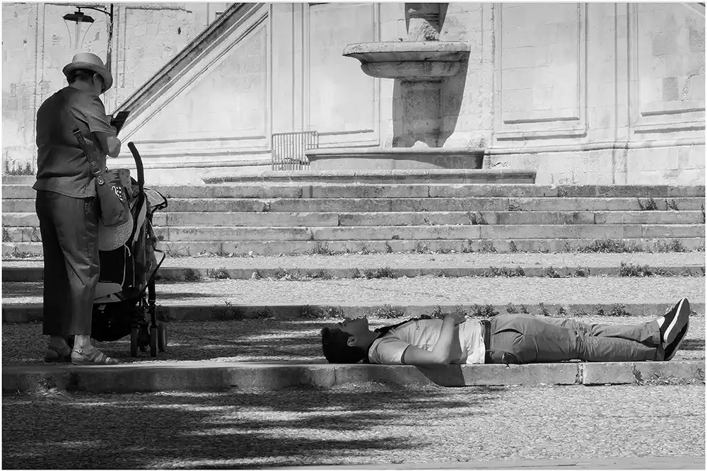 Photo de rue en couleur, couple se photographiant à la plage Festival d'Avignon homme couché et femme à la poussette
