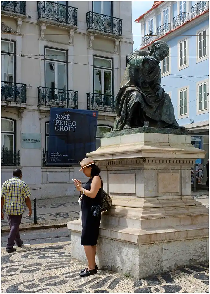 Femme au chapeau et smartphone à Porto. 